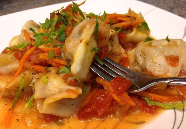 Cooked chuchvara in tomato sauce with herbs