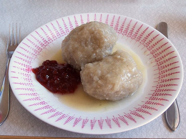 Two kroppkakor with lingonberries and melted butter