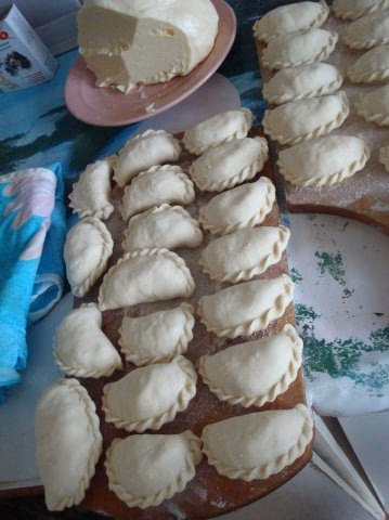 Raw Mari podkogyl with crimped edges on a wooden board