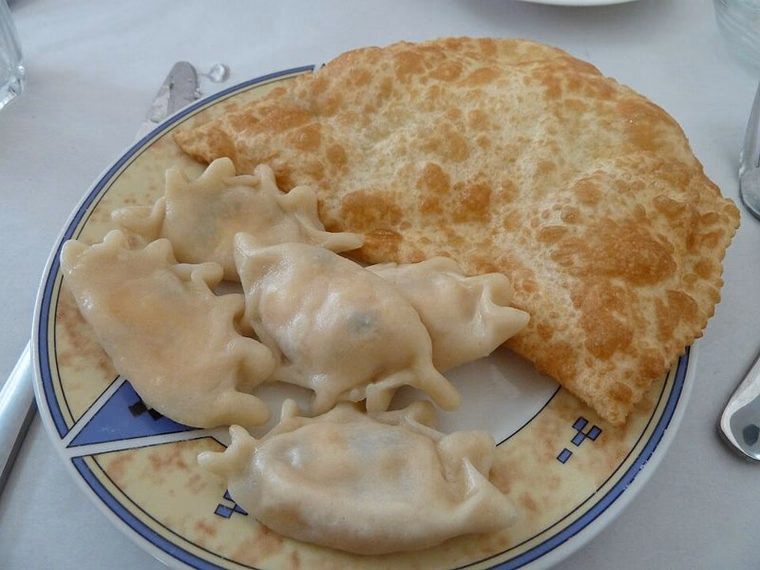 Boiled Circassian mataz dumplings beside a fried pastry