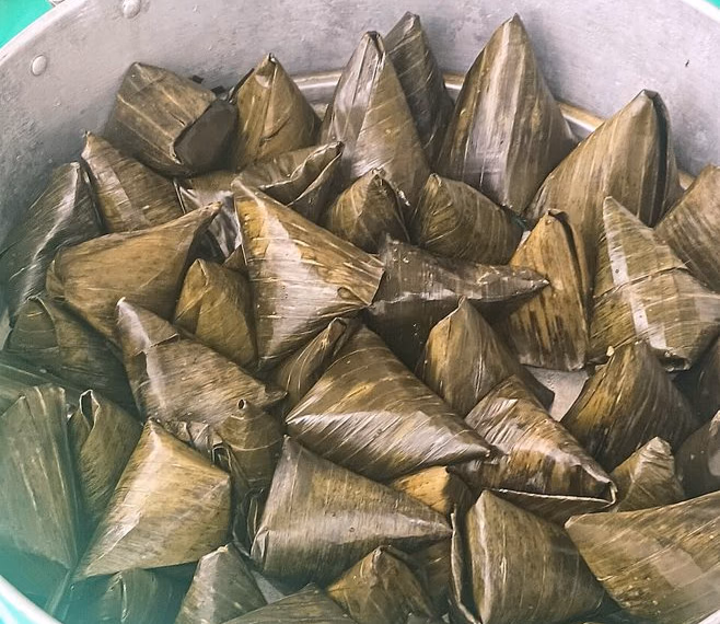 Pyramid-shaped num kom wrapped in banana leaf