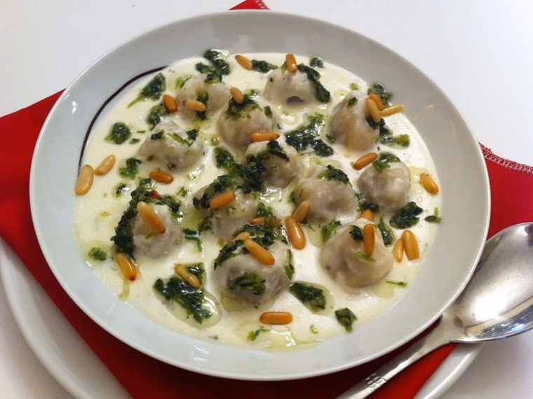 Shish barak in yogurt sauce with pine nuts and coriander