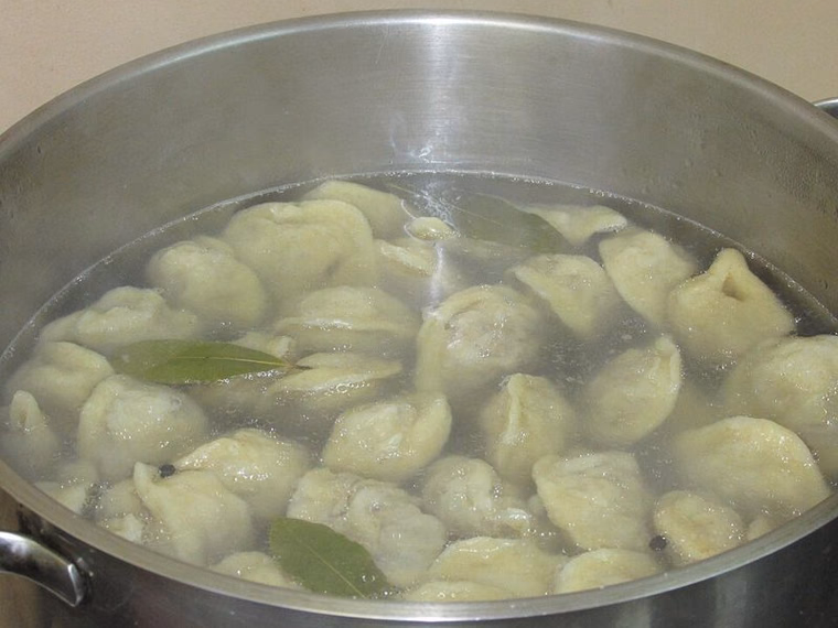 Udmurt pelnyan boiling in a pot with bay leaves